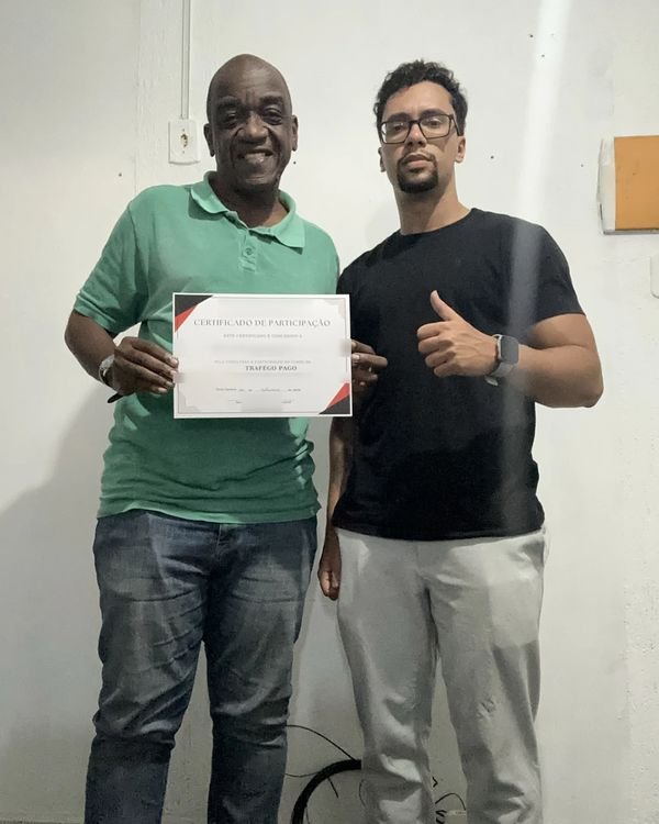Participante da turma presencial de tráfego pago mostrando o certificado ao lado de Rodrigo Ribeiro, em Nova Iguaçu.