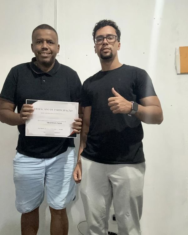 Participante da turma presencial de tráfego pago mostrando o certificado ao lado de Rodrigo Ribeiro, em Nova Iguaçu.
