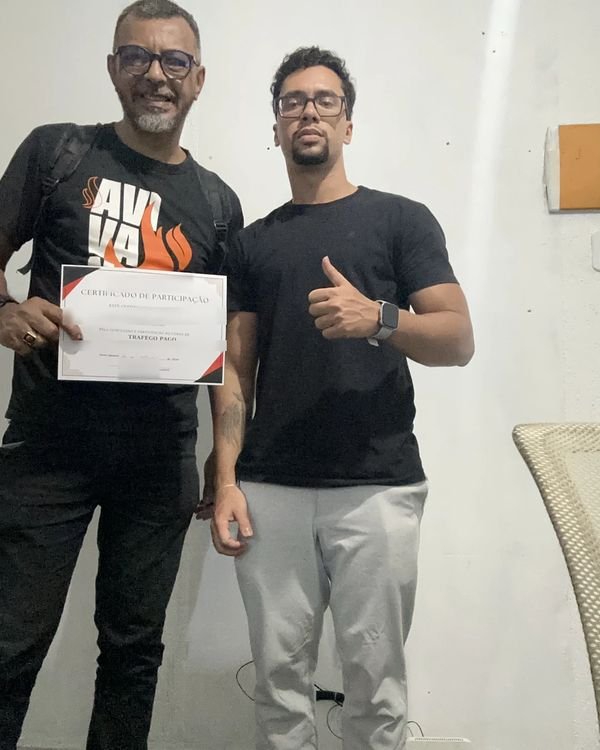 Participante da turma presencial de tráfego pago mostrando o certificado ao lado de Rodrigo Ribeiro, em Nova Iguaçu.