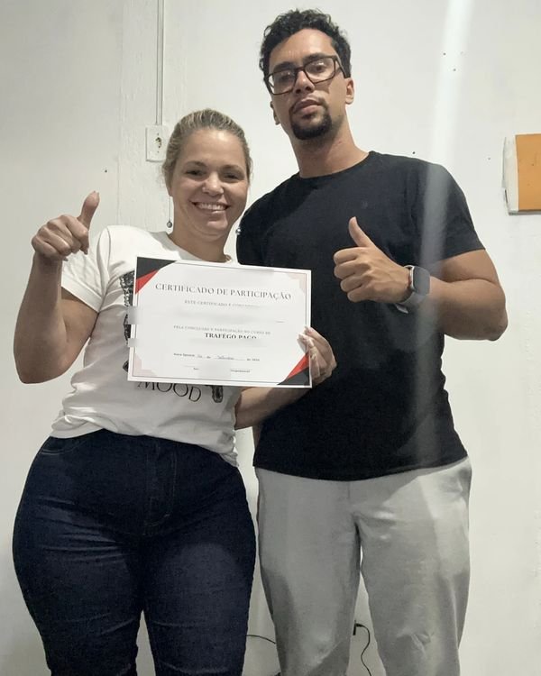 Participante da turma presencial de tráfego pago mostrando o certificado ao lado de Rodrigo Ribeiro, em Nova Iguaçu.